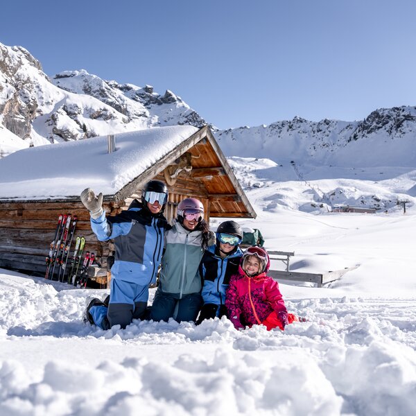 Famiglia sulla neve tra le baite in Val di Fassa | © Archivio Immagini ApT Val di Fassa - Mattia Rizzi